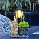 Solar Simulation Rabbit Ornament, charges by day and lights up automatically at night, three rabbits cluster around a street lamp with "WELCOME" bucket, warmly decorates courtyard and balcony, eco-friendly and healing./Rabbit's Kin