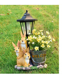 Solar Simulation Rabbit Ornament, charges by day and lights up automatically at night, three rabbits cluster around a street lamp with "WELCOME" bucket, warmly decorates courtyard and balcony, eco-friendly and healing./Rabbit's Kin