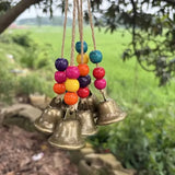 Handmade Bohemian Wind Chime, featuring jute rope with brass bells and colorful wooden beads, rings melodiously in the gentle breeze, adding natural romance to your home.