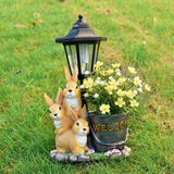 Solar Simulation Rabbit Ornament, charges by day and lights up automatically at night, three rabbits cluster around a street lamp with "WELCOME" bucket, warmly decorates courtyard and balcony, eco-friendly and healing./Resin flowerpot rabbit