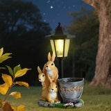 Solar Simulation Rabbit Ornament, charges by day and lights up automatically at night, three rabbits cluster around a street lamp with "WELCOME" bucket, warmly decorates courtyard and balcony, eco-friendly and healing./Resin flowerpot rabbit