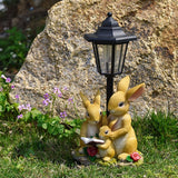 Solar Simulation Rabbit Ornament, charges by day and lights up automatically at night, three rabbits cluster around a street lamp with "WELCOME" bucket, warmly decorates courtyard and balcony, eco-friendly and healing./Resin flowerpot rabbit