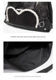 Stylish black tote backpack with heart embellishment - can be worn on one shoulder or as a backpack